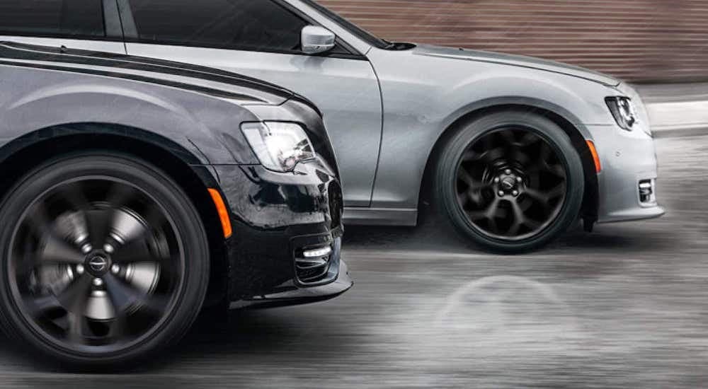 A black and a silver 2021 Chrysler 300 are shown from the side driving next to each other.