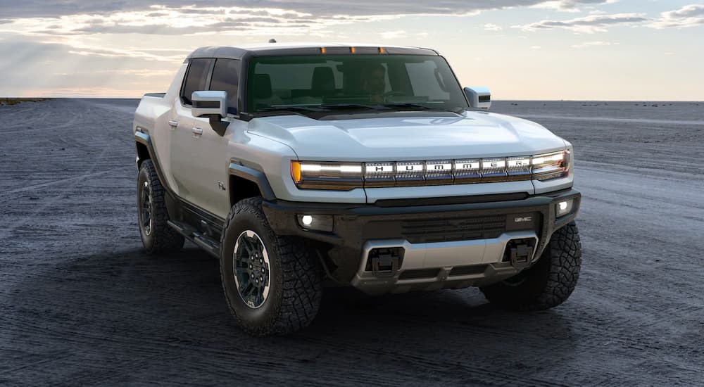 A silver 2021 GMC Hummer EV is shown from the front parked on sand, after leaving a GMC dealer near you.