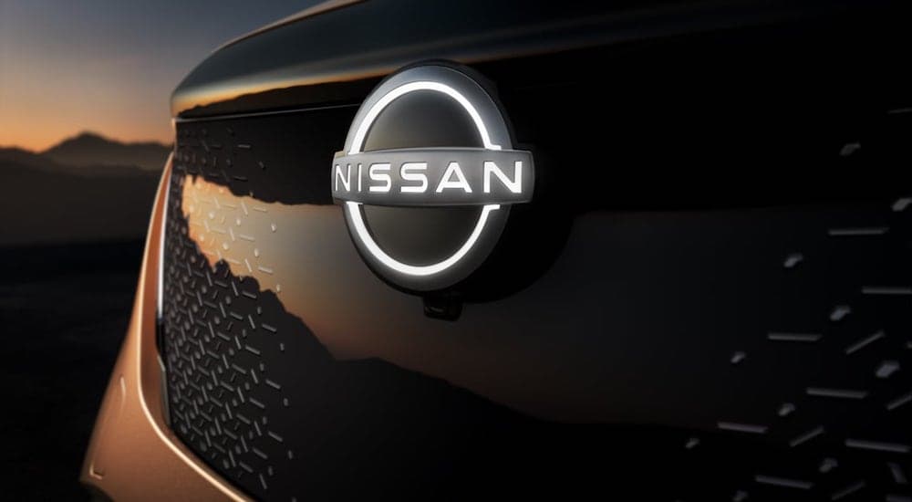 A close up shows the illuminated Nissan emblem on the grill of a 2021 Nissan Ariya.
