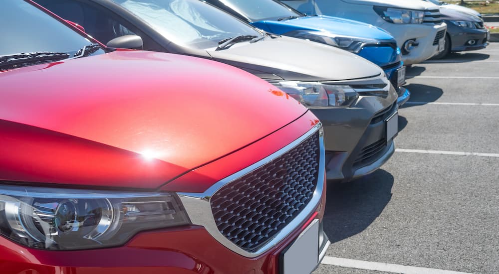 A close up shows a row of cars from a high angle.