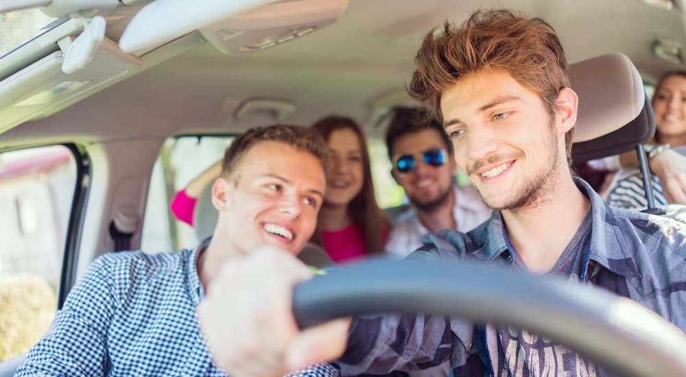 A teen driver is shown with a car full of friends.