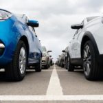 Two rows of used cars are shown from a low angle.