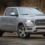 A gray 2019 used Ram Laramie is parked in front of a hill.