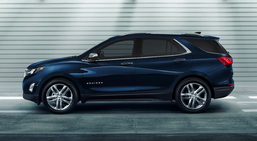 A dark blue 2021 Chevy Equinox is shown from the side in a parking garage.