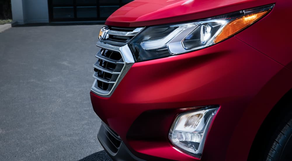 A close up shows the side of the front end of a red 2021 Chevy Equinox.