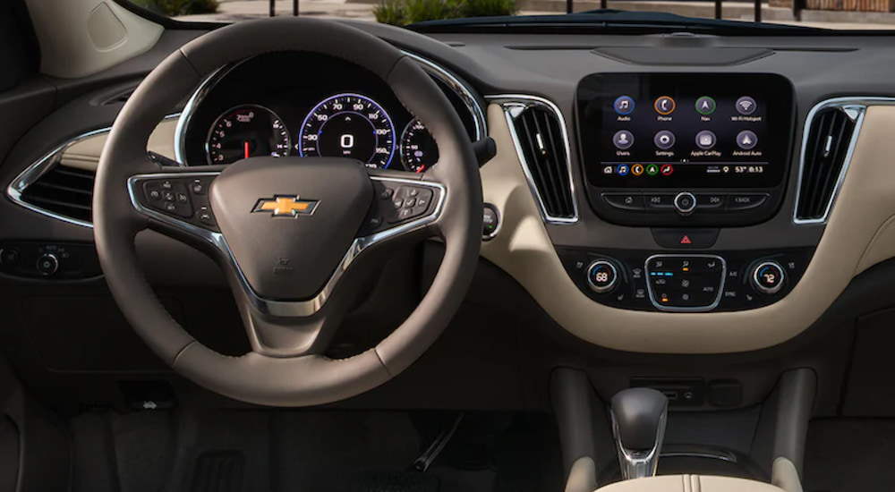 The interior of a 2021 Chevy Malibu shows the steering wheel and infotainment screen.
