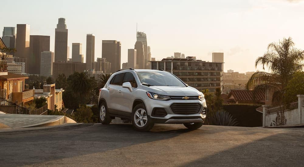 A white 2021 Chevy Trax is parked at the top of a hill in a city.