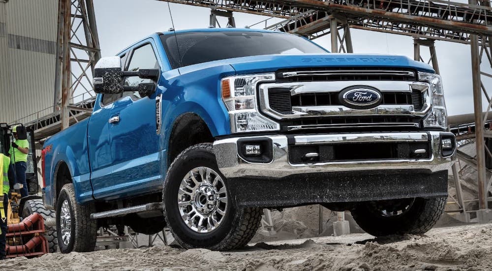 A blue 2021 Ford F-250 is parked at a job site.