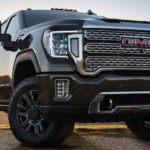 A black 2021 GMC Sierra 3500 HD is parked in a field.