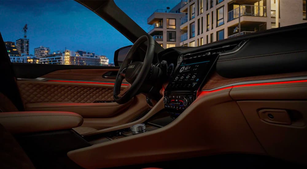 The brown and black interior and accent lighting are shown in a 2021 Jeep Grand Cherokee L.