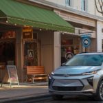 A silver 2022 Chevy Bolt EUV is parked in front of an outdoor gear store.