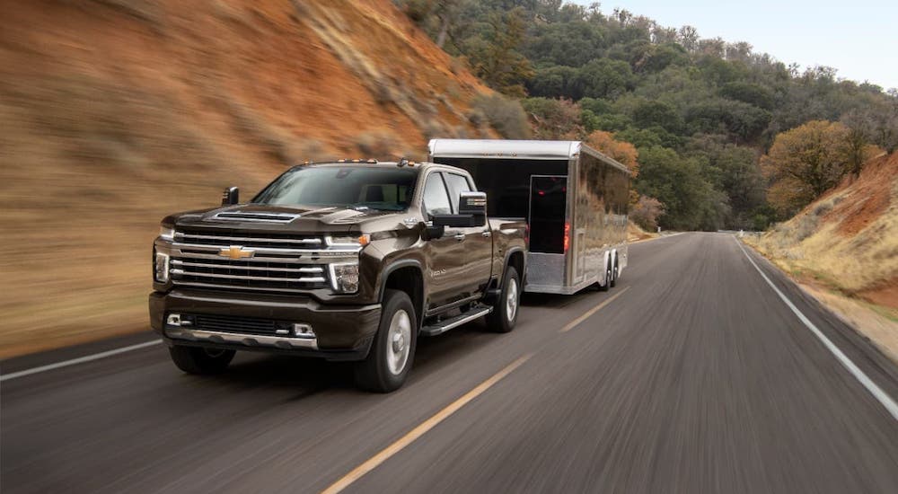 A black 2021 Chevy Silverado 2500HD is towing a black enclosed trailer.