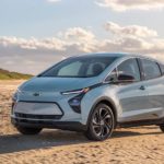 A light blue 2022 Chevy Bolt EV is parked on the beach after leaving the Chevy EV Dealer.