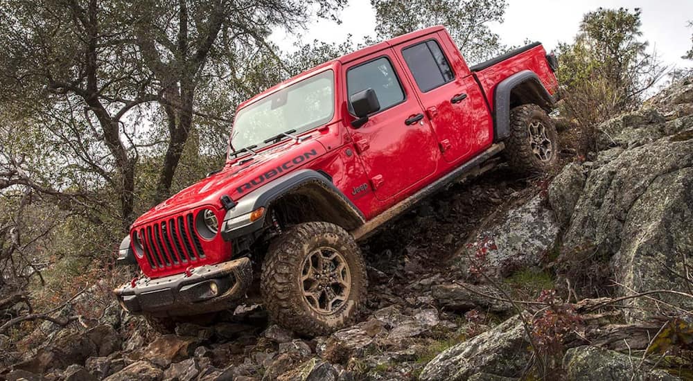 A red 2021 Jeep Gladiator is driving over rocks to get to a Jeep dealer near you.