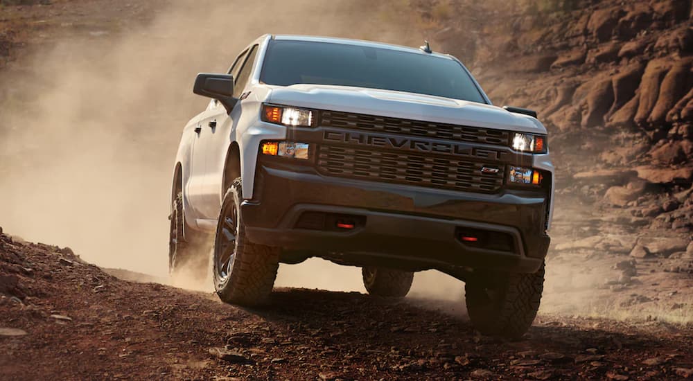 A white 2021 Chevy Silverado is driving through the desert.