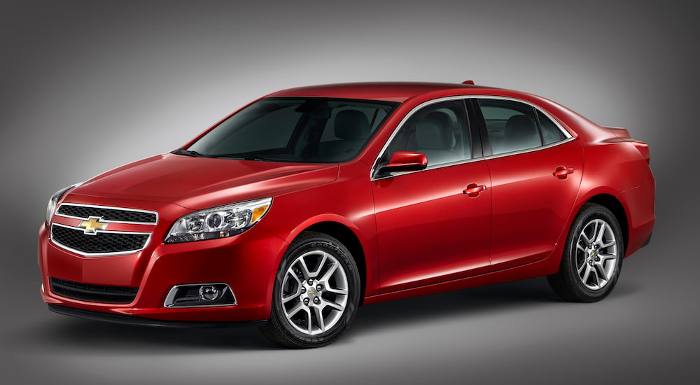 A red 2013 Chevrolet Malibu Eco is angled left.