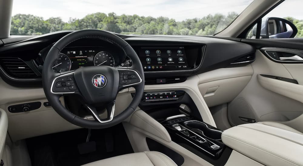 The interior of a 2021 Buick Envision shows the steering wheel and infotainment screen.