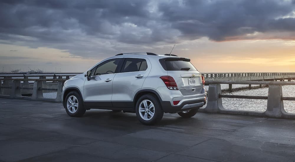 A silver 2021 Chevy Trax is parked on a jetty at sunset after after participating in a 2021 Chevy Trax vs 2021 Chevy Trailblazer comparison.