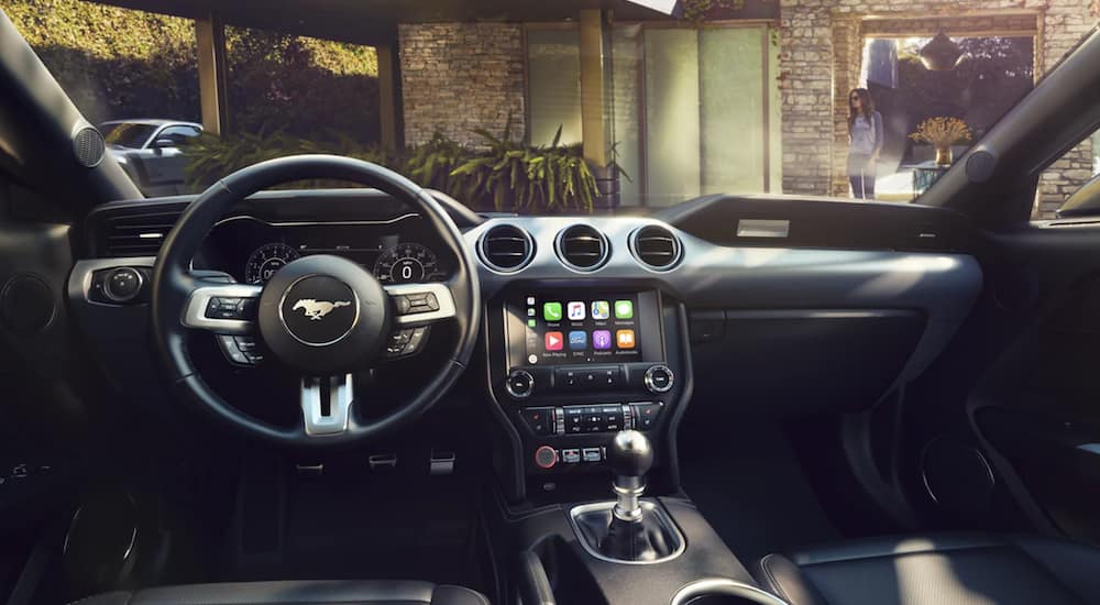 The interior of a 2021 Ford Mustang shows the steering wheel and infotainment screen.