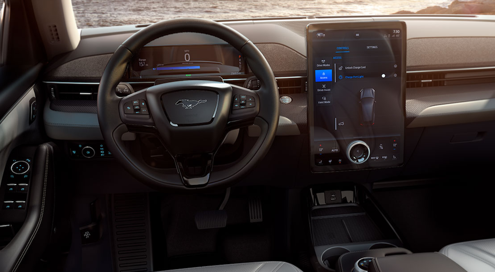 The interior of a 2021 Ford Mustang Mach-E is showing the steering wheel and infotainment screen. 