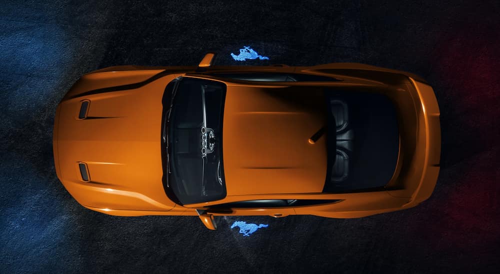 An orange 2021 Ford Mustang is shown from above.