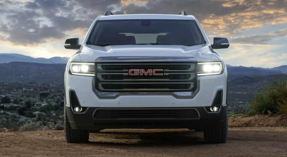 A white 2021 GMC Acadia is shown from the front overlooking a mountain.
