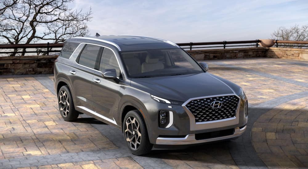 A grey 2021 Hyundai Palisade is parked on a brick driveway.