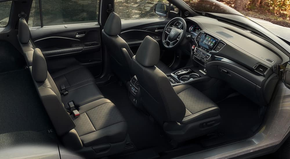 The interior of a 2021 Honda Passport shows two rows of seating, the steering wheel and infotainment screen.