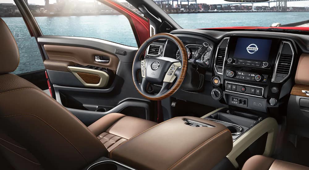 The interior of a 2021 Nissan Titan XD shows the steering wheel and infotainment screen.