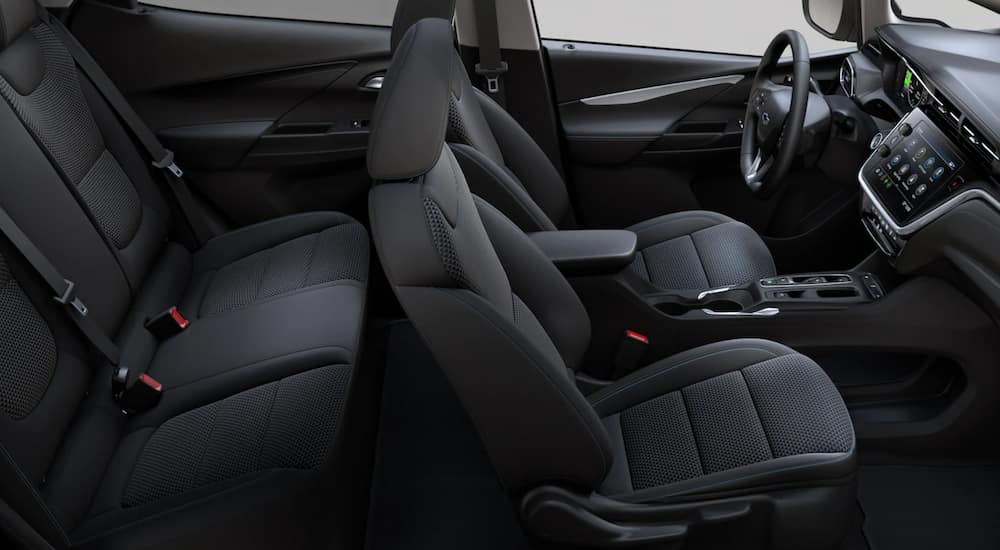 The interior of 2022 Chevy Bolt EV shows 2 rows of seating, the steering wheel, and infotainment screen.