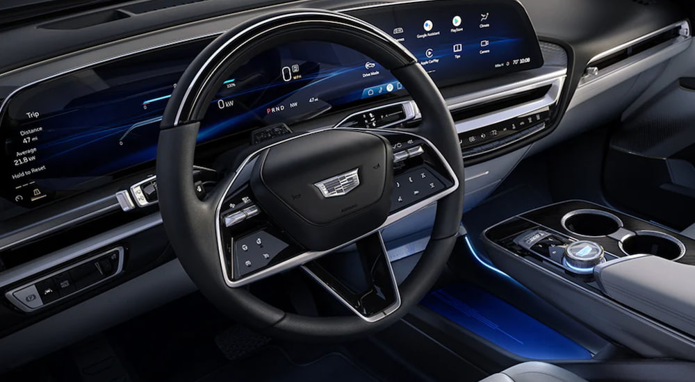 The interior of a 2023 Cadillac Lyriq shows the steering wheel and infotainment screen. 