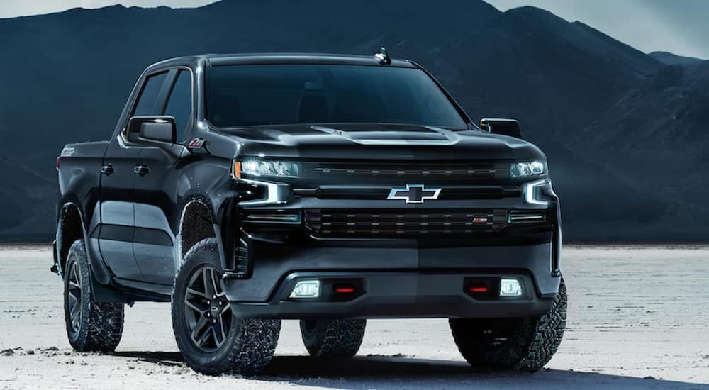 A black 2021 Chevy Silverado 1500 is parked on a salt flat after leaving a Chevy Silverado dealer.