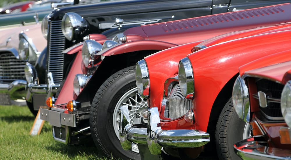 A close up shows a row of classic cars.