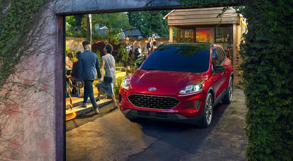 A red 2021 Ford Escape is parked in a modern garden.