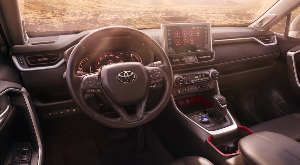 The steering wheel and infotainment screen are shown in a 2021 Toyota RAV4.