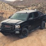 A black 2016 GMC Sierra is parked in a desert after searching Used Car sales