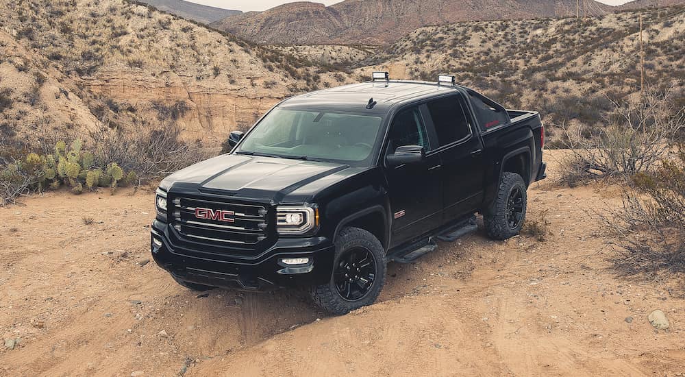 A black 2016 GMC Sierra is parked in a desert after searching Used Car sales