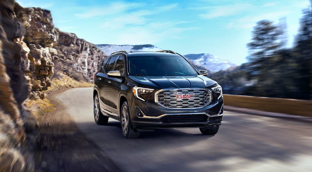 A black 2020 GMC Terrain is shown driving from the front.