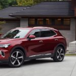 A red 2021 Buick Envision is parked in front of a modern home after winning a 2021 Buick Envision vs 2021 Ford Edge comparison.