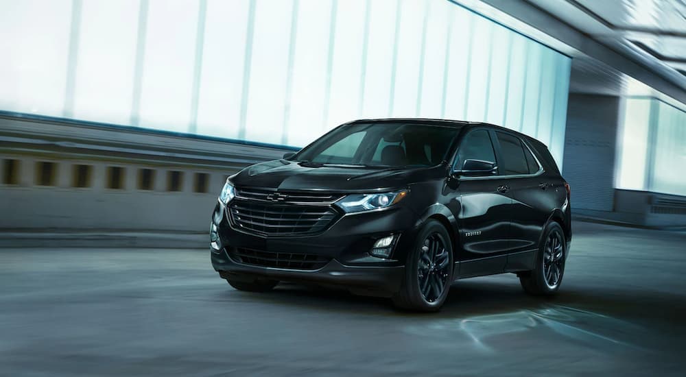 A black 2021 Chevy Equinox is driving away after winning a 2021 Chevy Equinox vs 2021 Honda CR-V comparison.