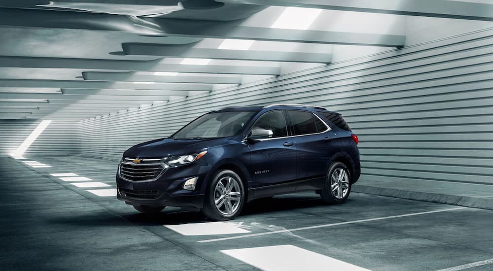 A blue 2021 Chevy Equinox is parked in a parking garage after winning a 2021 Chevy Equinox vs 2021 Honda CR-V comparison.