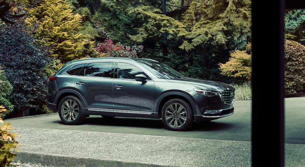 A grey 2021 Mazda CX-9 is shown from the side parked on gravel.