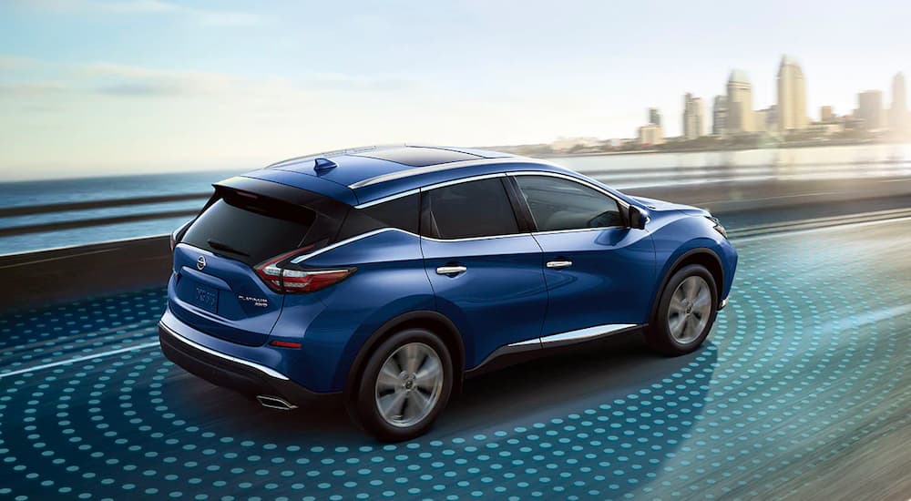 A blue 2021 Nissan Murano is shown with simulated sensor lines on the highway.