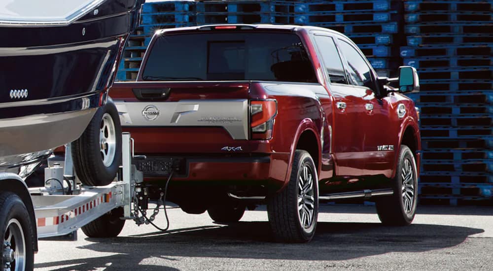 A red 2021 Nissan Titan is towing a boat.
