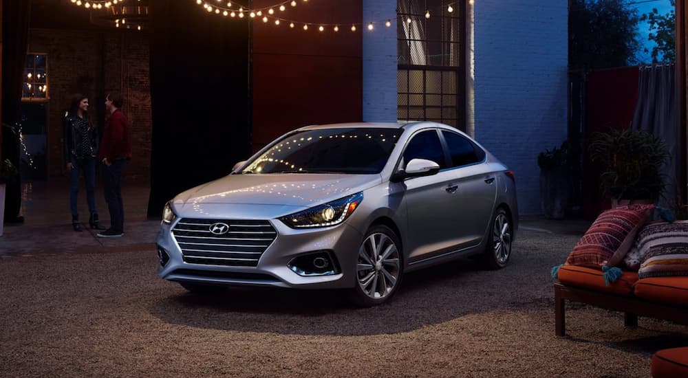 A silver 2021 Hyundai is parked outside of a house in the evening.