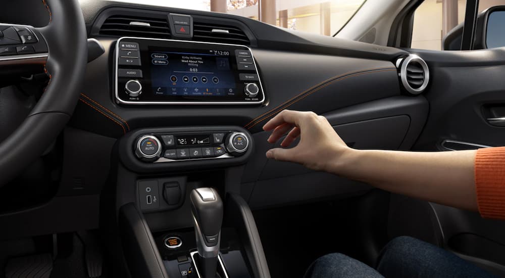 The interior of a 2021 Nissan Versa shows the infotainment screen.