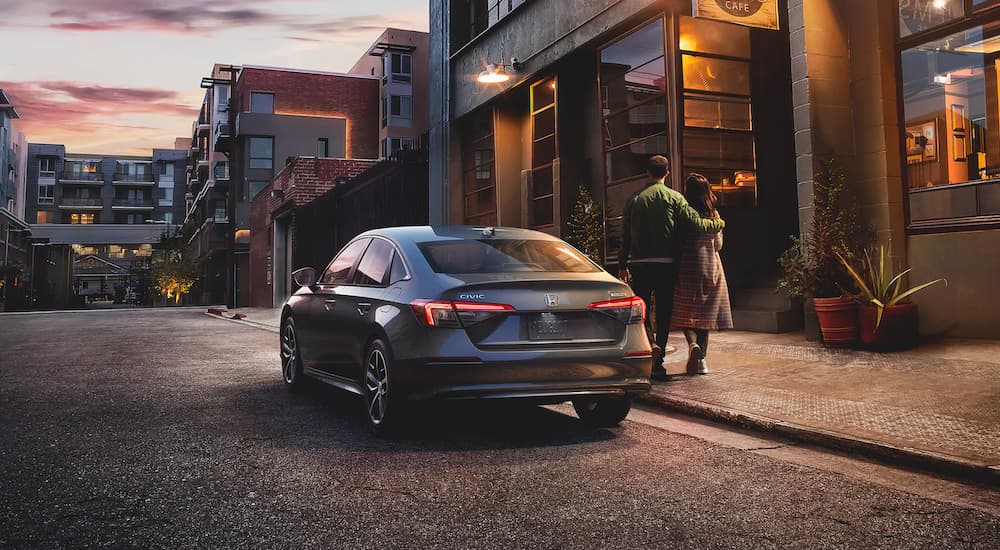 A grey 2022 Honda Civic Touring is shown from the rear parked on a city street.