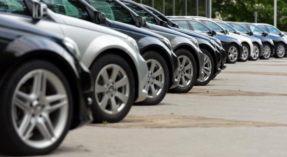 A lot of cars are parked at an angle at a Chevrolet dealer.