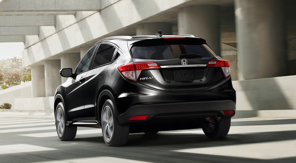 A black 2021 Honda HR-V EX-L is shown from the back driving through an underpass.