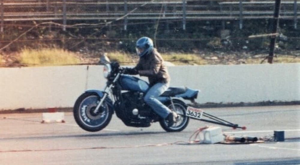 Sherman is shown driving a motorcycle at a track.